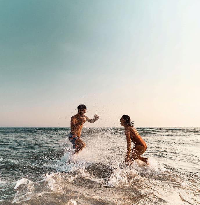 cute couple playing at the beach