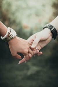 A close-up of two people holding hands