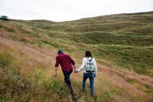 A couple holds hands while hiking
