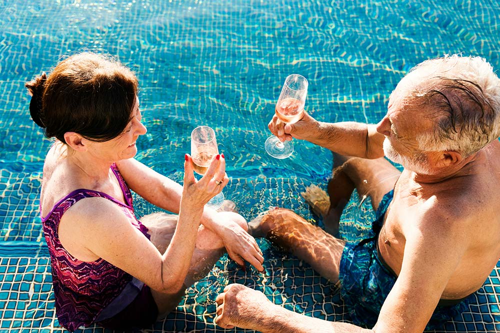 A mature couple relaxing together in a swimming pool.