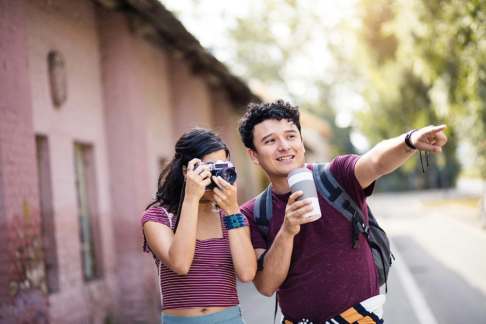 A woman uses a vintage camera to take a photo while a man standing next to her