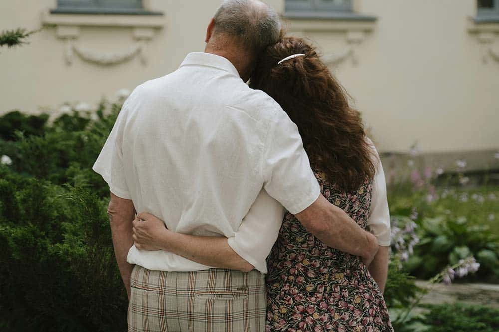Man and Woman Embracing in Front of a House