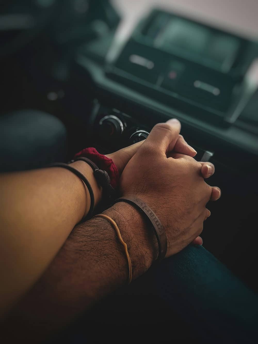 Two people holding hands inside a car