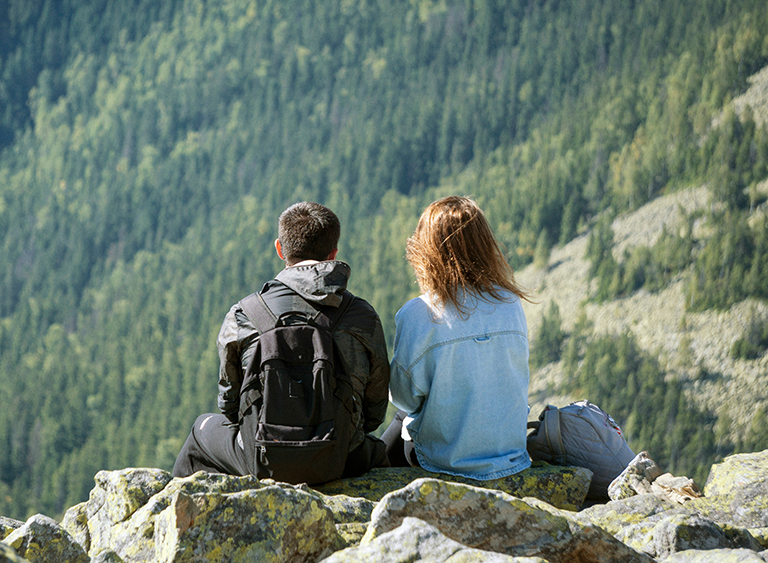 a-couple-of-people-sitting-on-top-of-a-mountain-