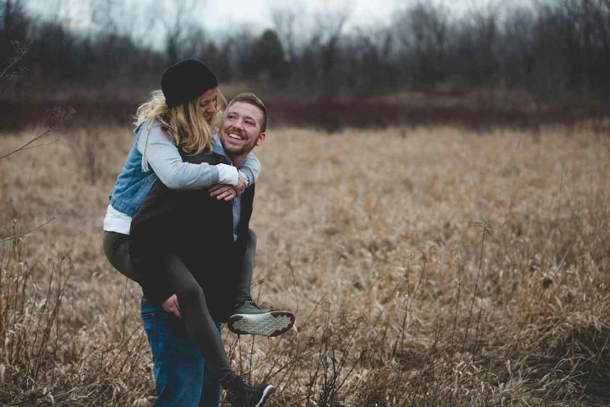 Smiling couple enjoying time together outdoors, symbolizing connection and intimacy in relationships.