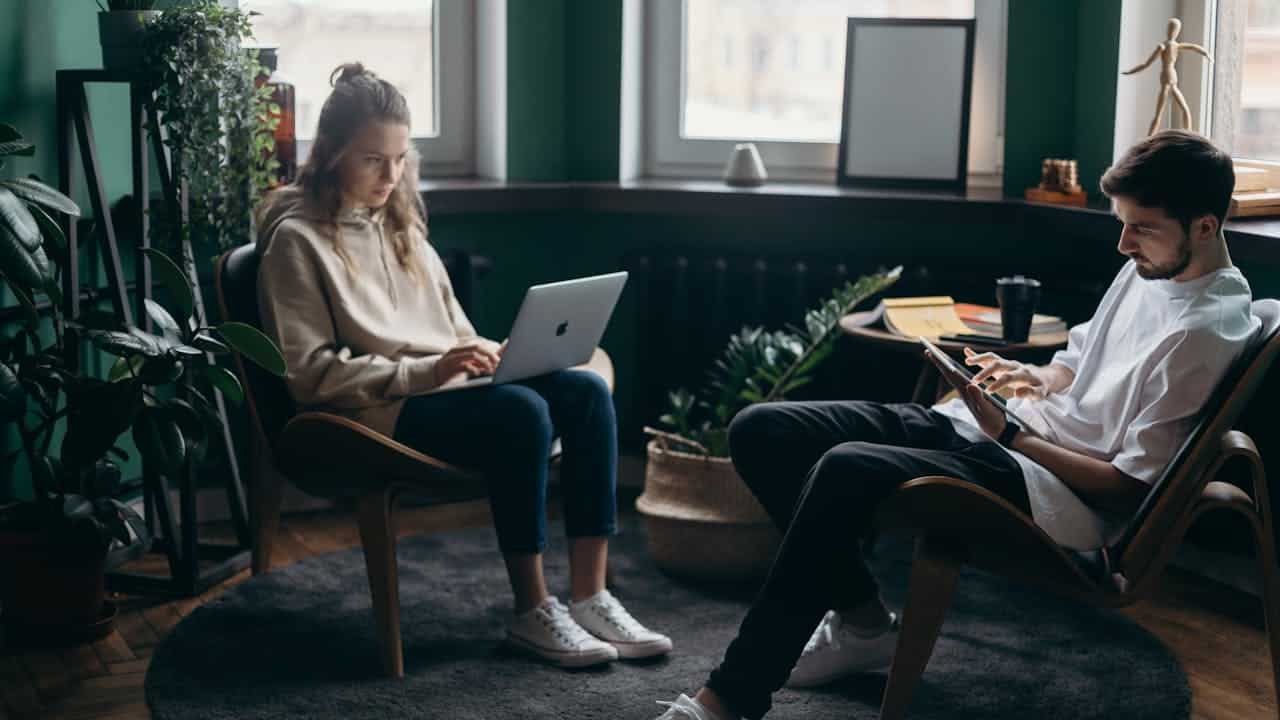 High-functioning couple sitting apart in silence, reflecting emotional distance after repeated arguments